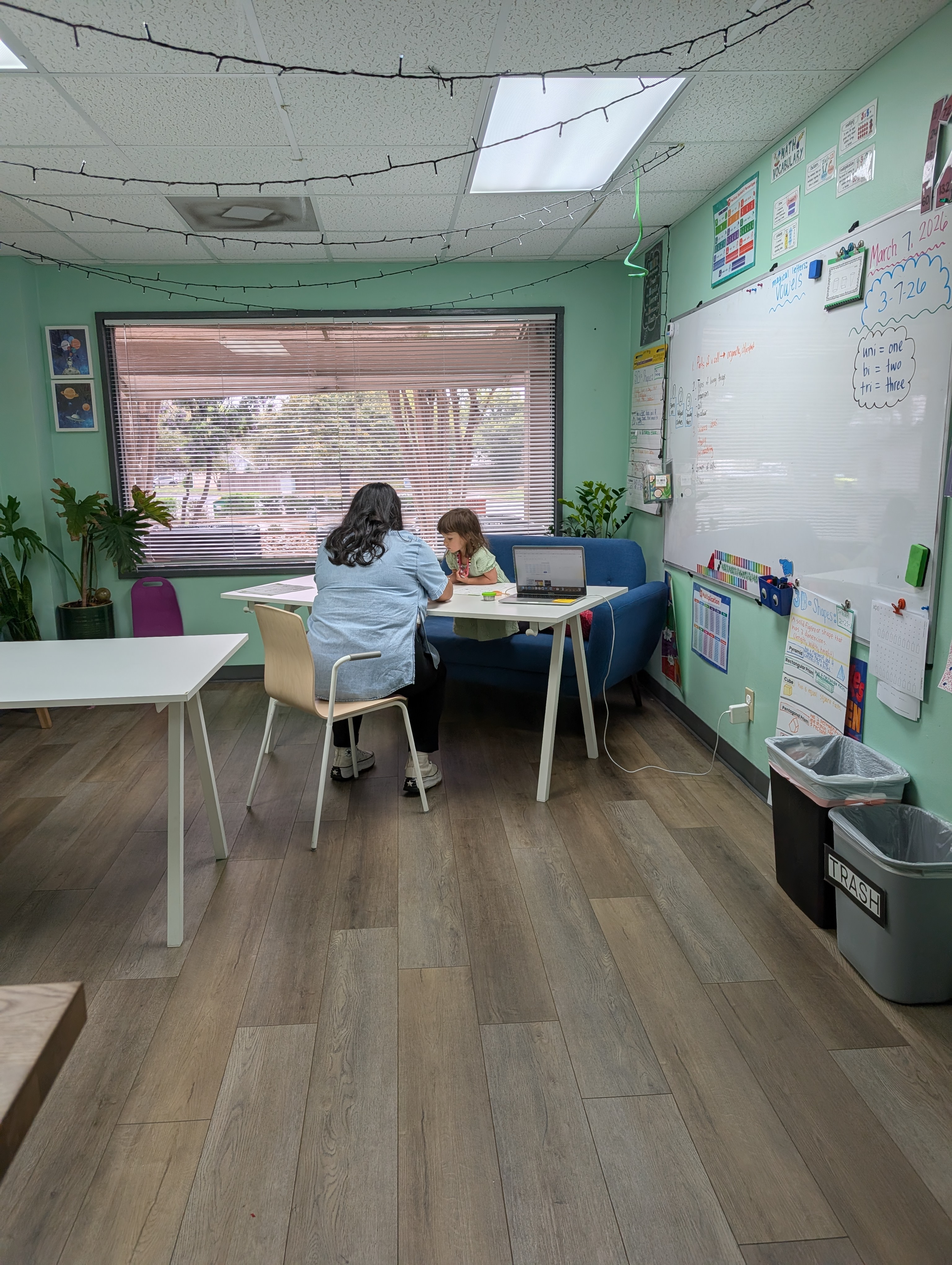 Teacher working one-on-one with a student at a desk in the classroom